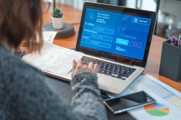Persona realizando pago de servicios y llevando control en una computadora